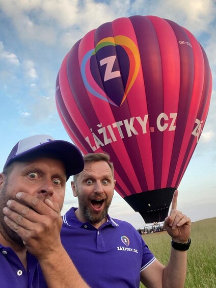 Two people standing in front of a colorful hot air balloon with the logo 'Z' and the website 'zazitky.cz'. 2