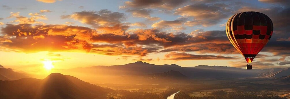 A hot air balloon over a mountainous landscape during sunset. 5