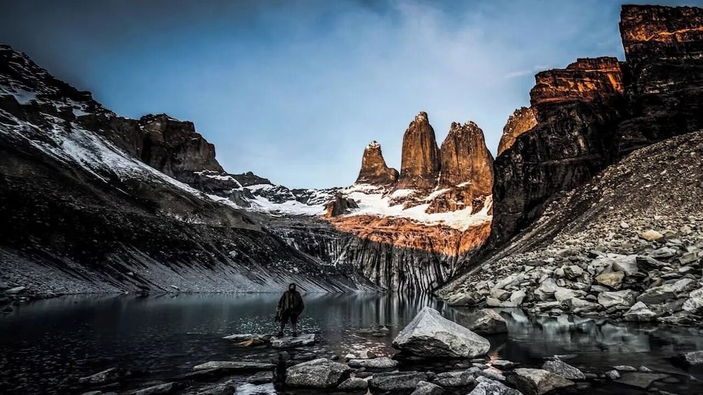 A mountainous landscape with a clear lake, rocky terrain, and distinct rock formations. 1