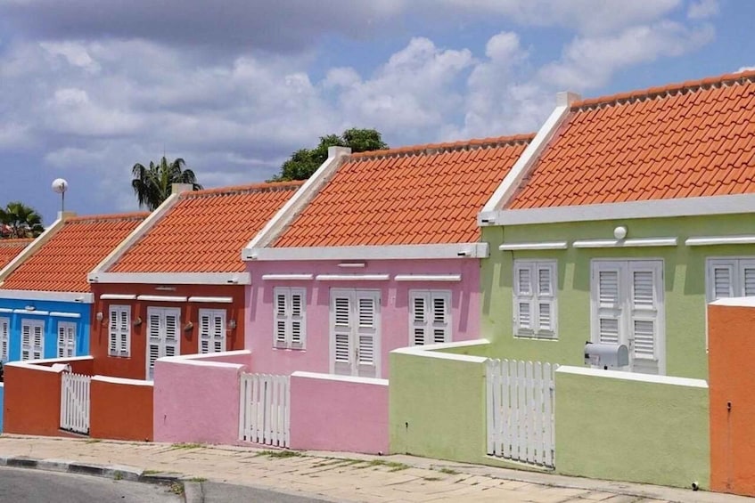 A row of colorful houses with red-tiled roofs and white shutters. 2