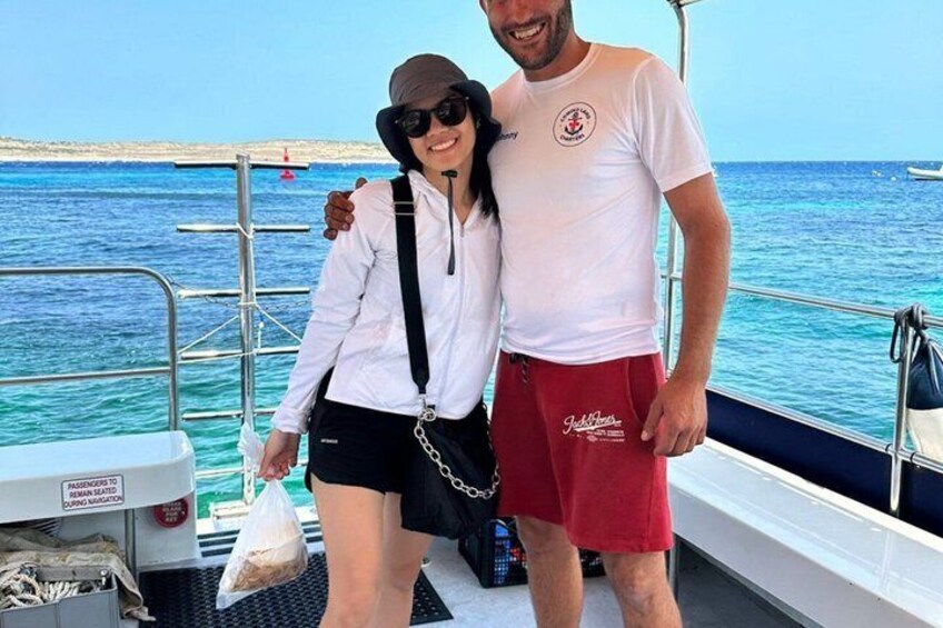 Zwei Personen in einem Boot auf dem klaren, blauen Meer, mit einer fernen Küstenlinie im Hintergrund. 2