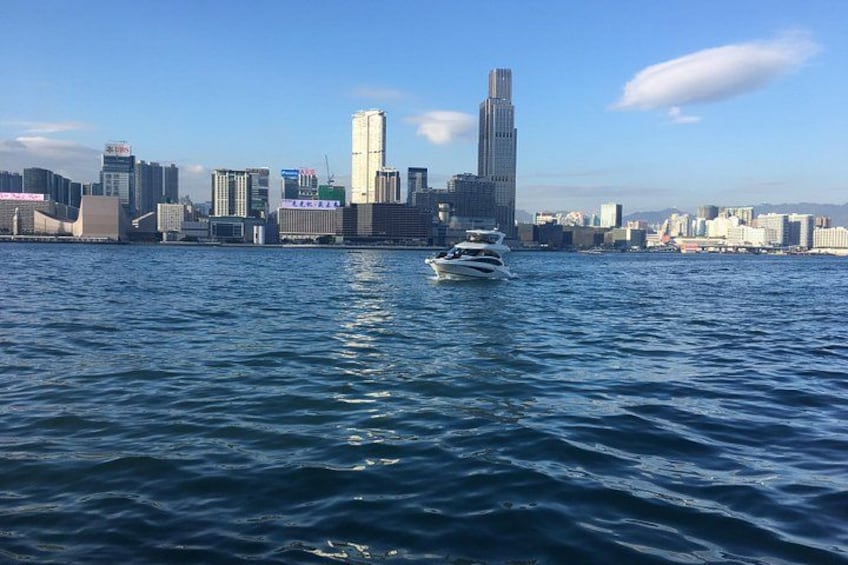 A city skyline with a body of water in the foreground and a boat. 1