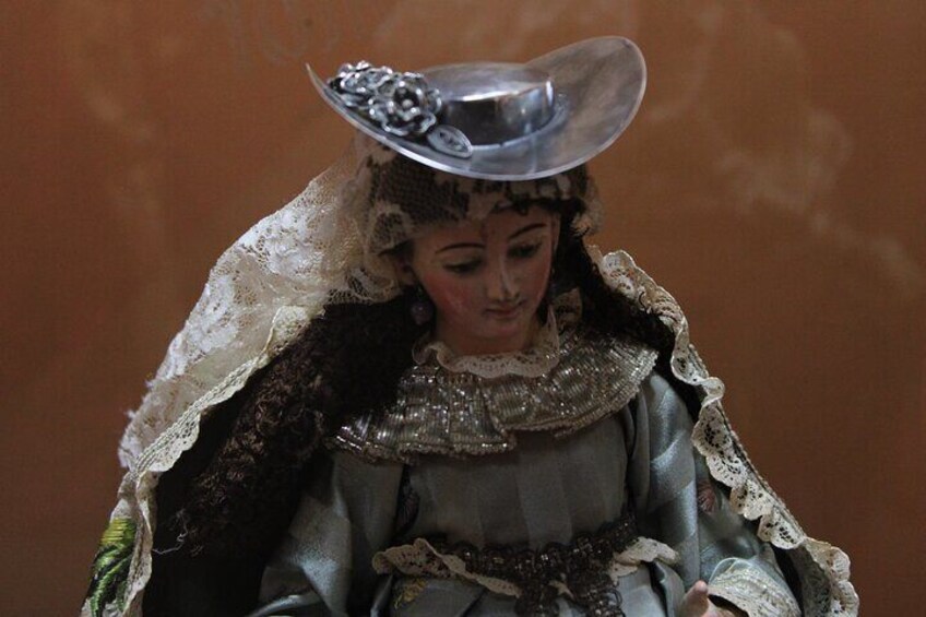 A figure in a detailed costume with a hat and lace. 2