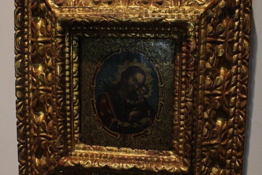 A framed artwork with a dark background and a central figure. 1