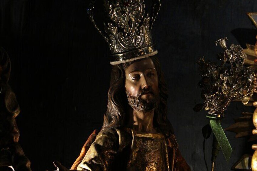 A statue with a crown and a green ribbon. 4