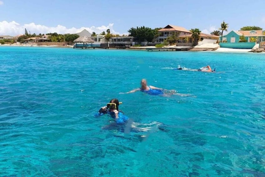 A clear blue sea with people swimming and snorkeling. 3