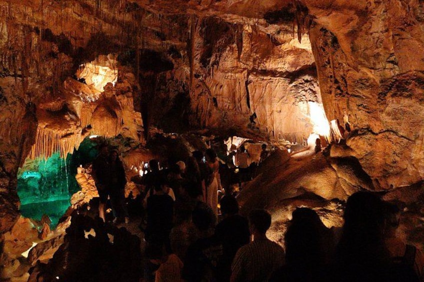 A cave with stalactites and stalagmites, illuminated by artificial lighting. 3