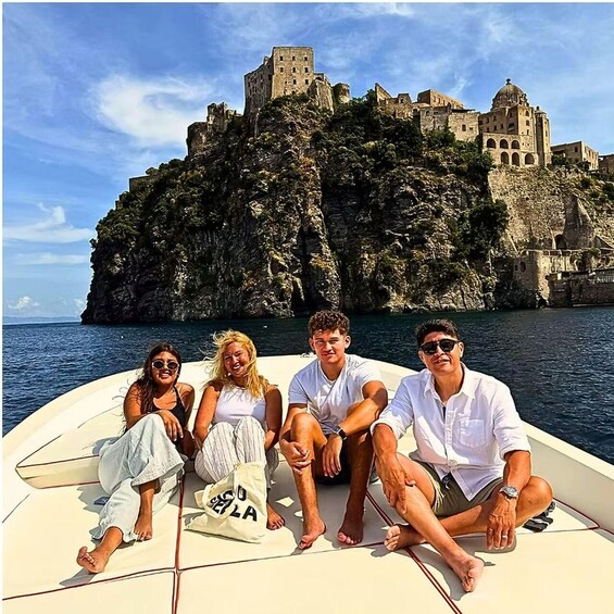 A boat with people on a rocky coastline with a castle in the background. 4
