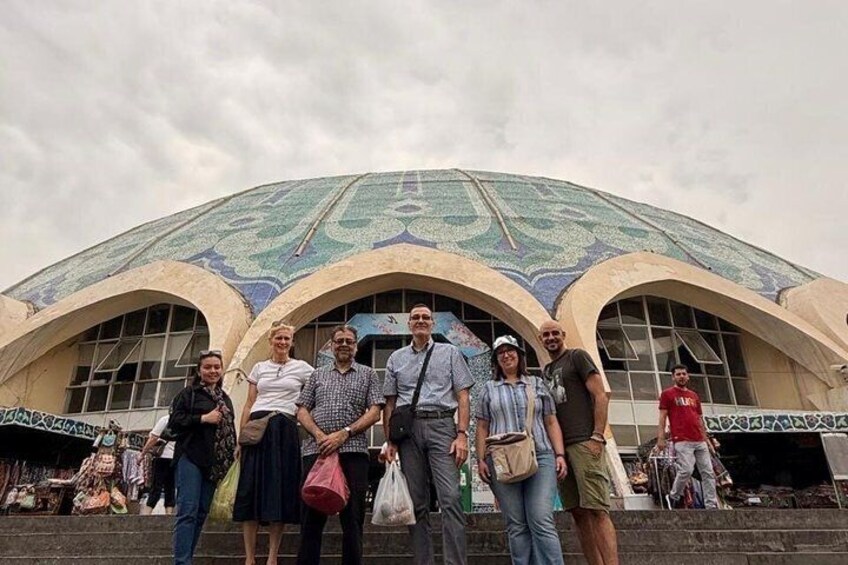 Un groupe de personnes se tient devant un grand bâtiment à coupole, dont le toit est orné de motifs. 4