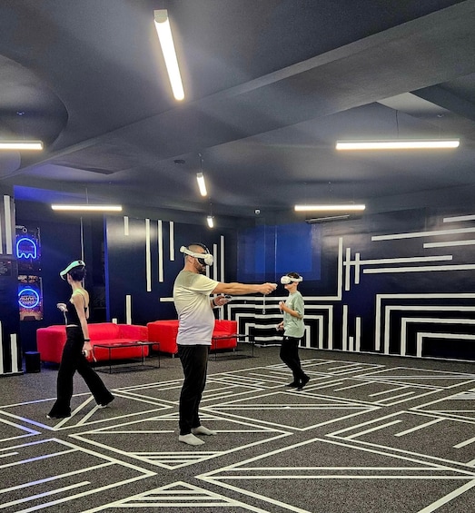A VR gaming room with geometric patterns on the floor and a neon sign in the background. 5