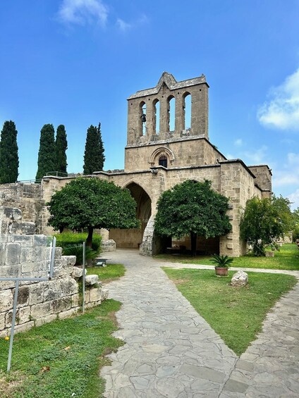 A historic stone building with arched doorways and a bell tower. 2