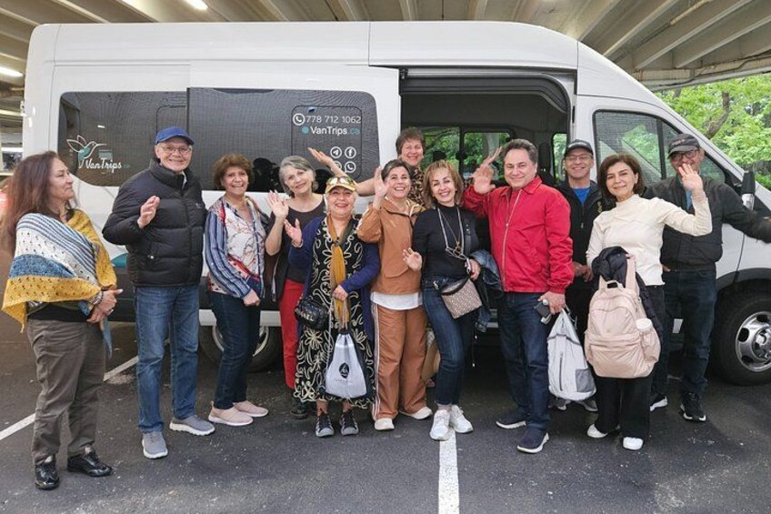 En gruppe mennesker står foran en hvid varevogn med teksten 'VanTrips'. 2