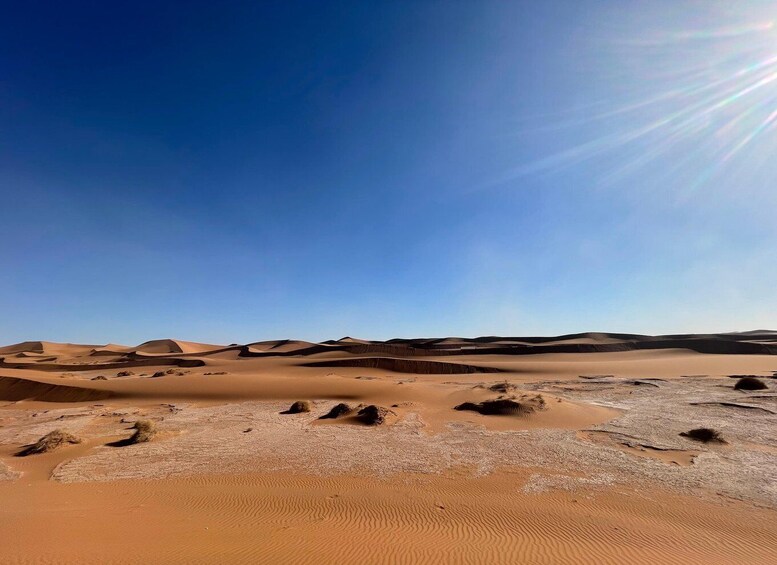 A desert landscape with sand dunes and a clear blue sky. 3