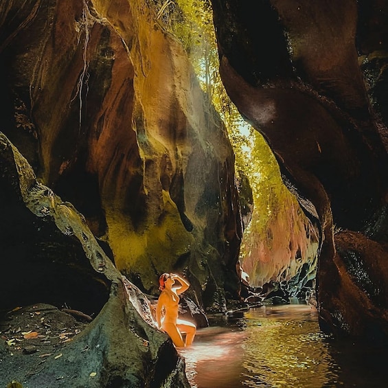 A person in a cave with water and rock formations. 3