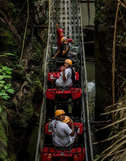 Three people in white shirts and yellow helmets on a narrow waterway, surrounded by dense greenery. 5
