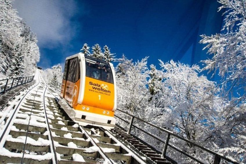 Un train circule sur une voie ferrée enneigée, entouré d’arbres couverts de neige. 1