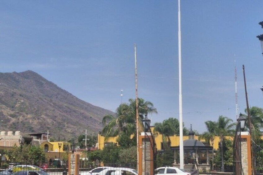 Une montagne, un grand poteau blanc et un bâtiment jaune avec une porte. 2