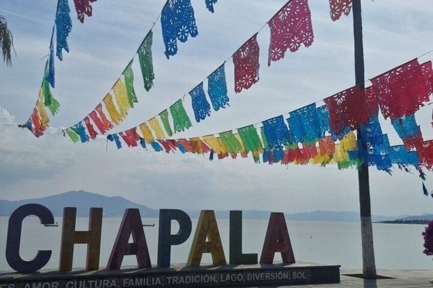 Une enseigne portant l’inscription « CHAPALA », sur laquelle sont fixés des drapeaux aux couleurs vives. 1