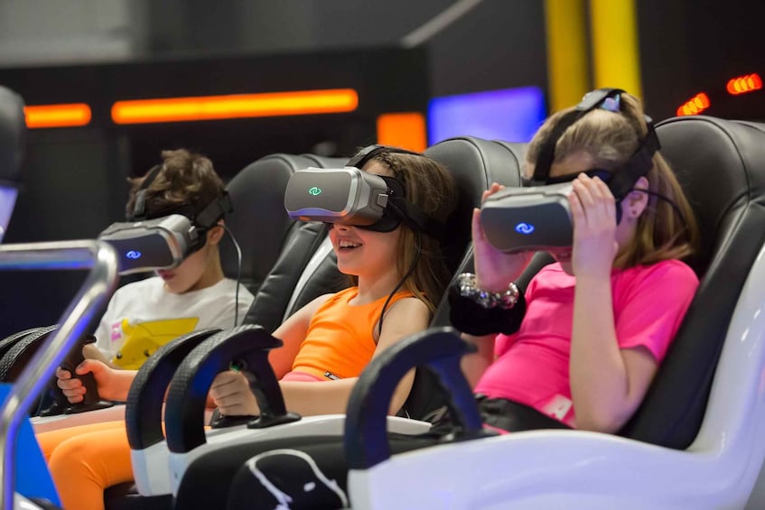 People in VR headsets in a ride simulator. 2