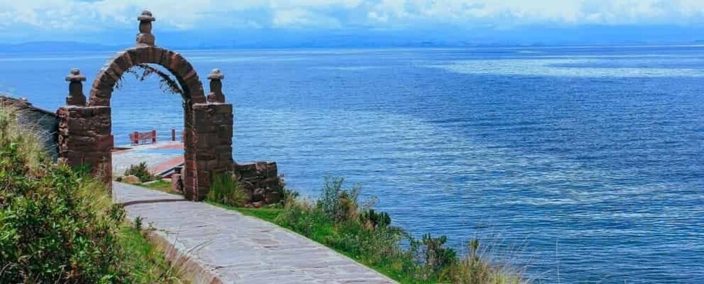 A stone archway leading to a coastal path. 3