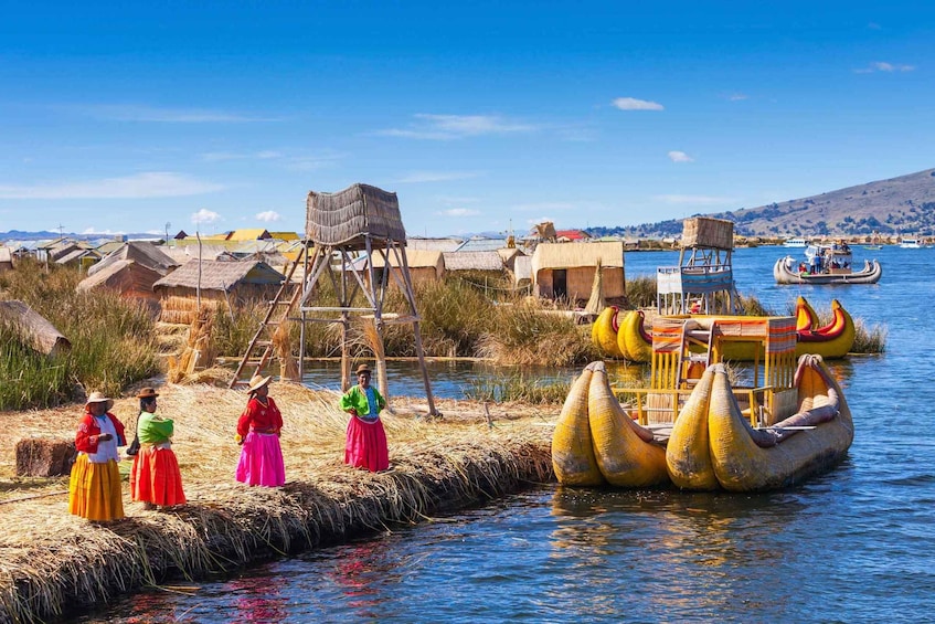 A traditional floating village with people in colorful attire, a wooden structure, and boats on the water. 1
