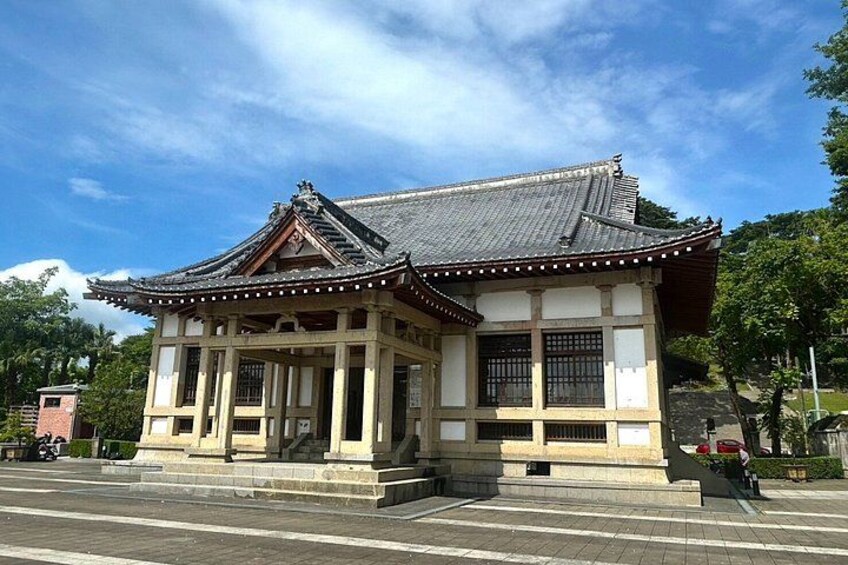 Un edificio japonés tradicional con tejado de tejas y columnas de madera. 3