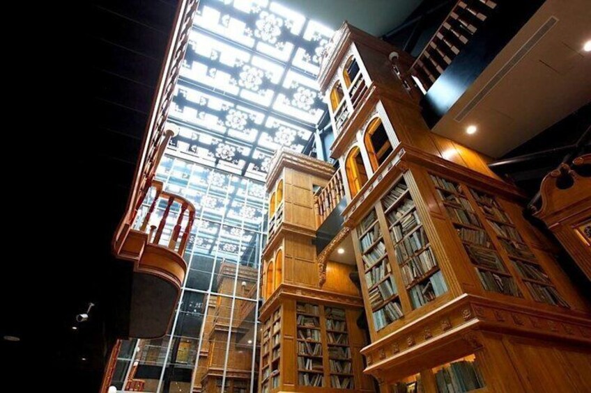 L'intérieur d'une bibliothèque avec des étagères en bois et un plafond en verre. 4