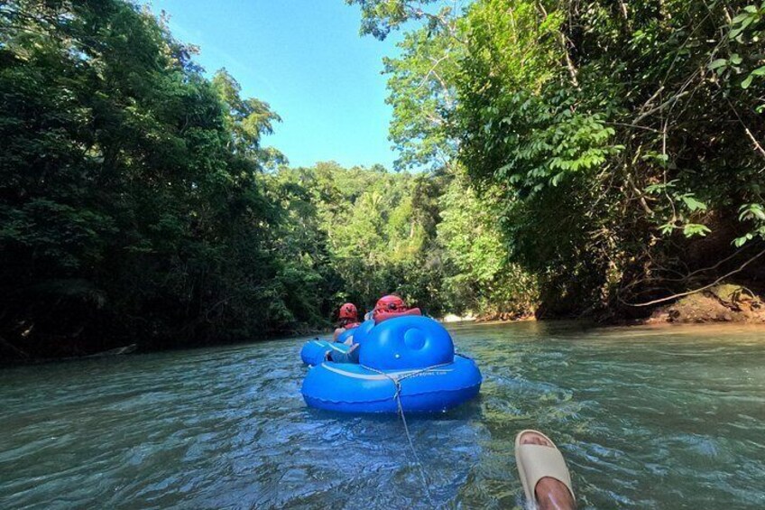 Una balsa inflable azul en un río rodeado de abundante vegetación verde. 4