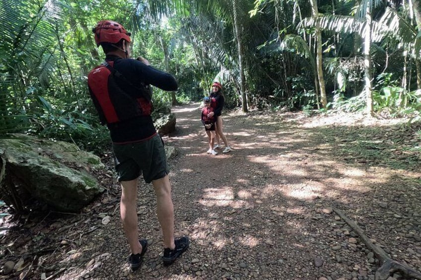 Una persona fotografiando a otra que camina por un sendero en el bosque. 2