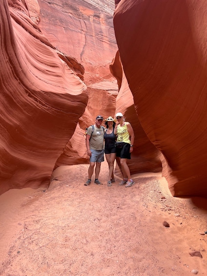 A group of people standing in a narrow canyon with red rock walls. 5