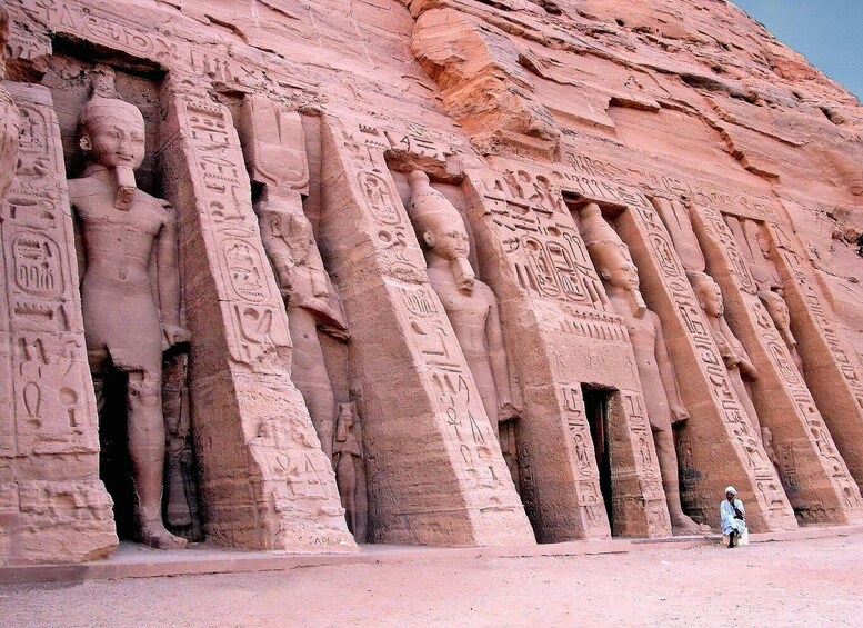 A row of ancient Egyptian statues carved into a cliff. 2