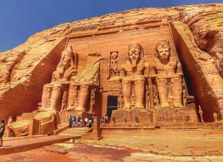 A large rock-cut temple with towering statues of pharaohs. 4