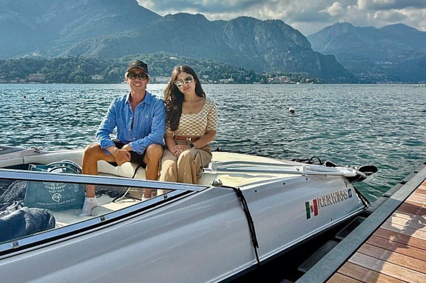 A couple on a boat with a mountainous landscape in the background. 1