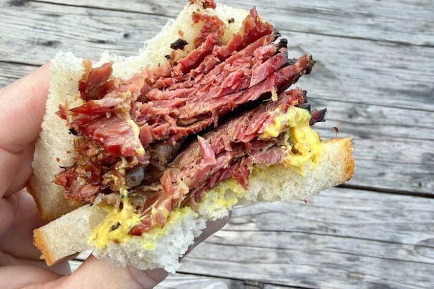 A sandwich with meat and cheese on a wooden surface. 5