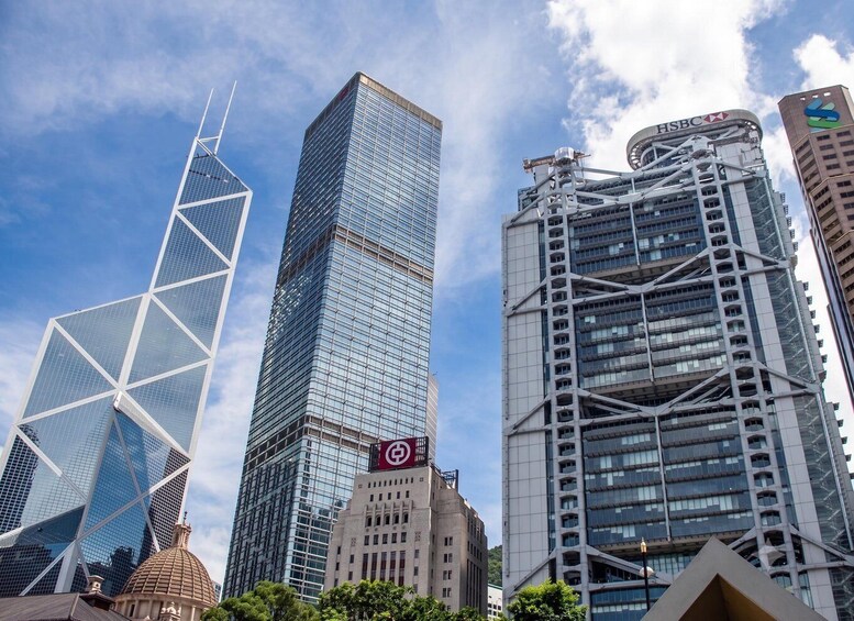 A cityscape with modern skyscrapers, including a distinctive building with a white lattice structure and another with a red HSBC logo. 4