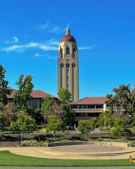 A building with a prominent tower and dome, surrounded by trees and a landscaped area. 3