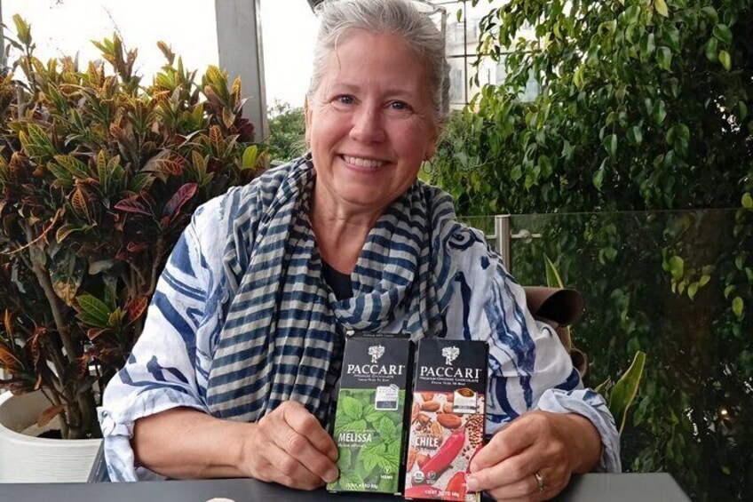 A person seated at a table with two boxes of Paccari chocolate bars. 3