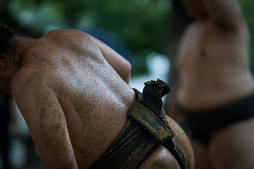 Una persona con un mawashi, cinturón de luchador de sumo, señal de un evento de lucha libre sumo. 4
