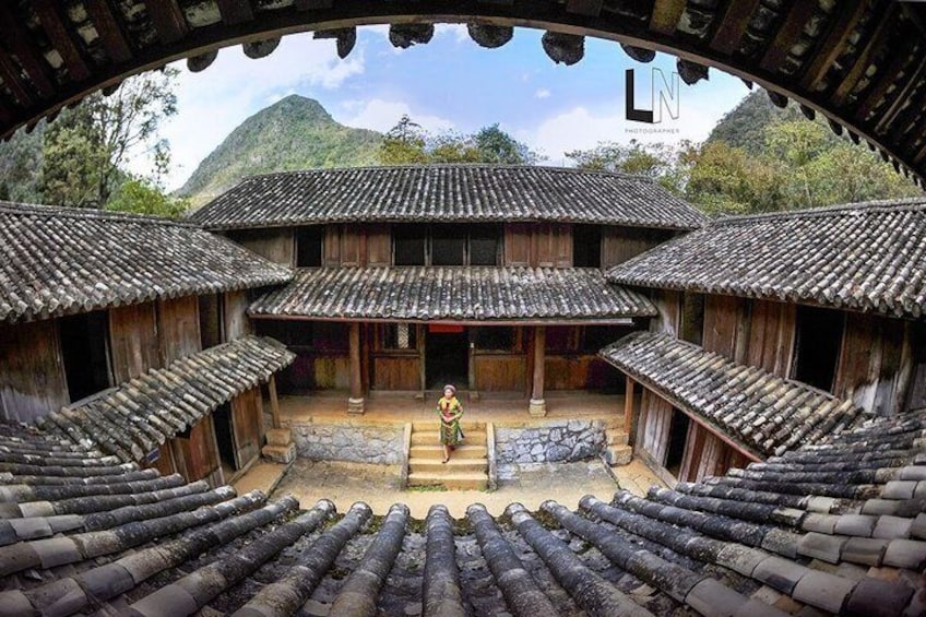 A traditional courtyard with wooden buildings and a central stone platform. 4