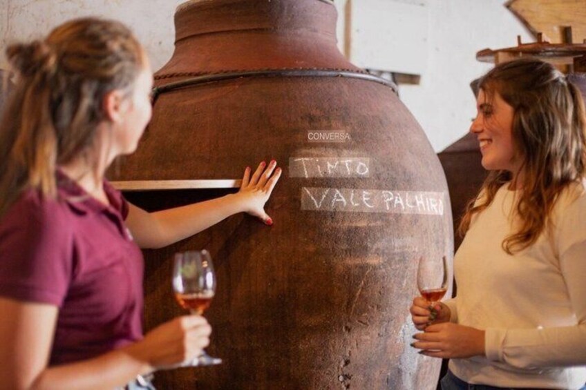Two people inspecting a large wooden barrel with inscriptions. 1