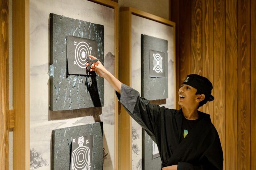 A person aiming at a target with a dartboard. 1