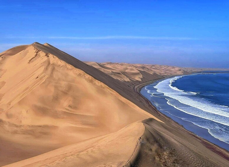 A desert landscape with sand dunes and a coastline. 1