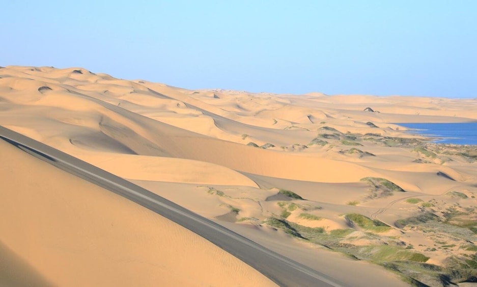 A desert landscape with sand dunes and a road. 2