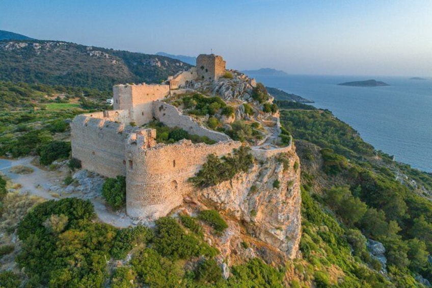 A historic stone castle perched on a cliff overlooking the sea. 1