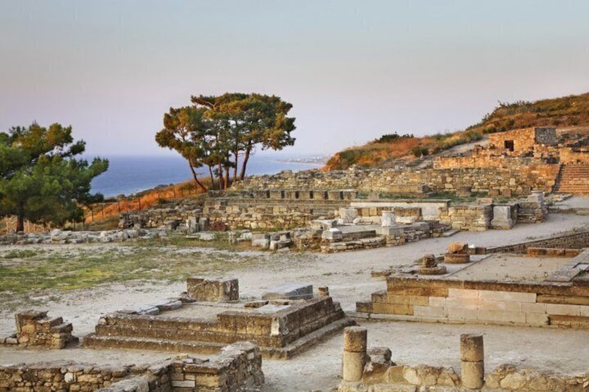 Ancient ruins with stone structures and a tree in the background. 4