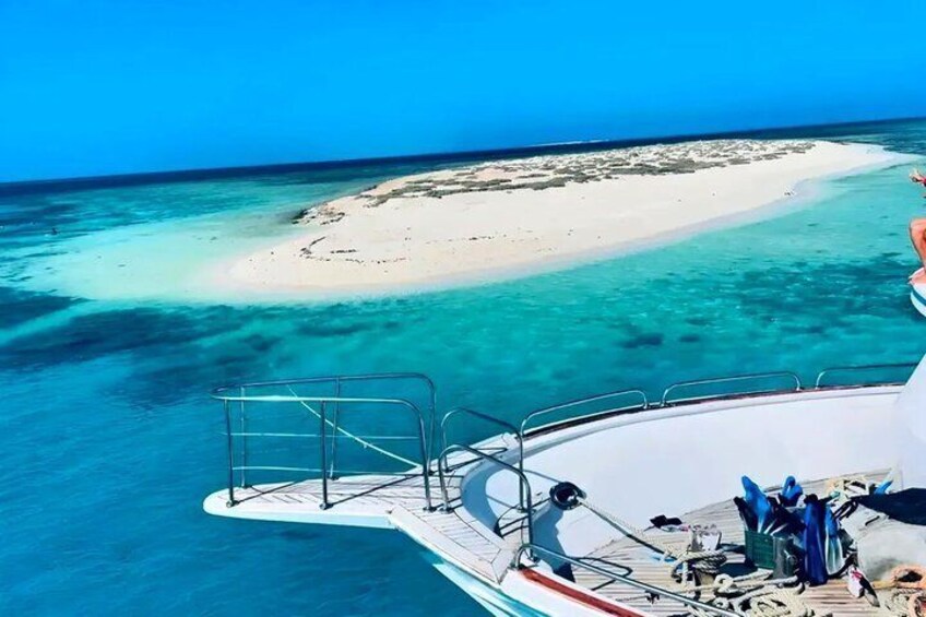 Een boot met uitzicht op een turquoise zee en een wit zandstrand. 2