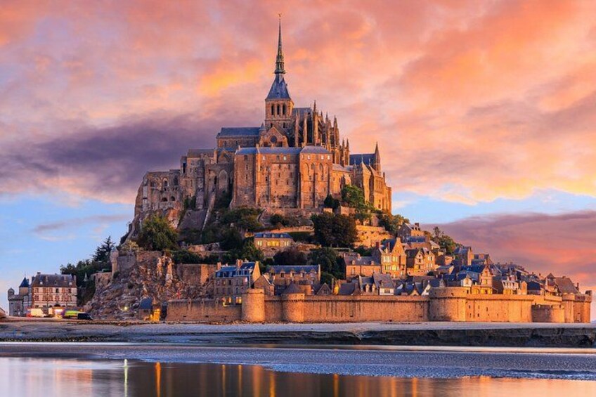 A historic castle on a hill with a river in the foreground. 1