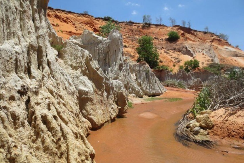 Ein Fluss fließt durch eine felsige Schlucht mit weißen Klippen und rötlich-brauner Erde. 2