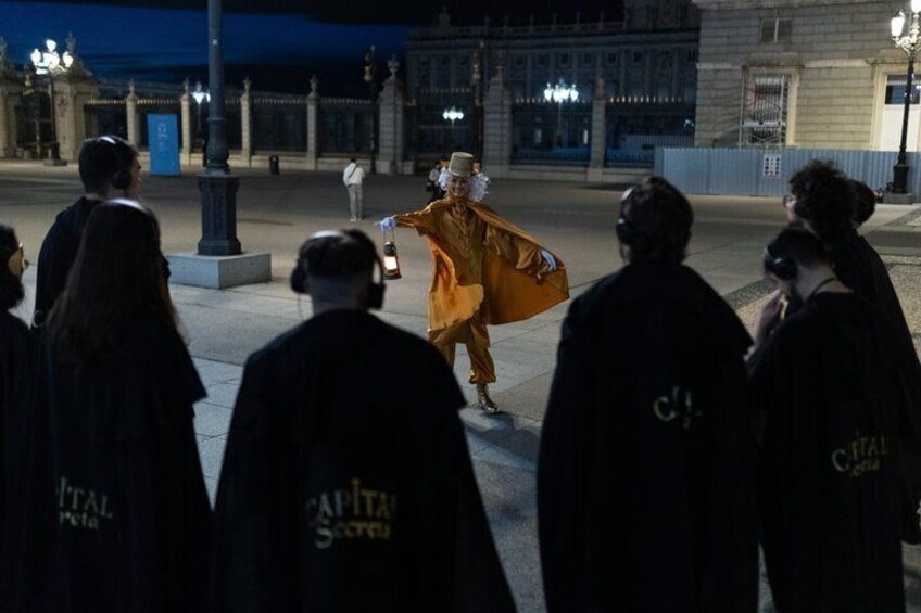A person in a yellow costume walking on a city street at night. 3