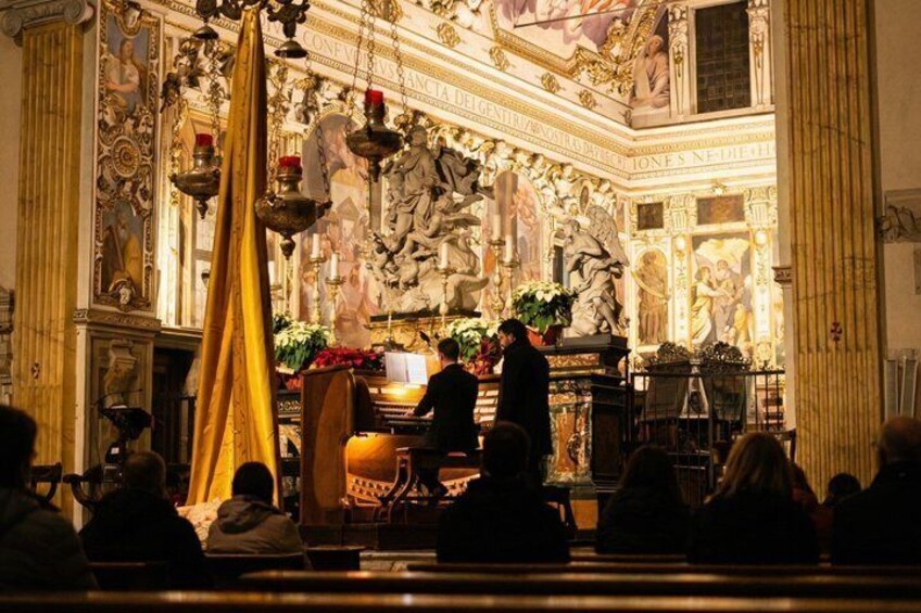 An ornate church interior with a central altar, religious statues, and a golden curtain. 5